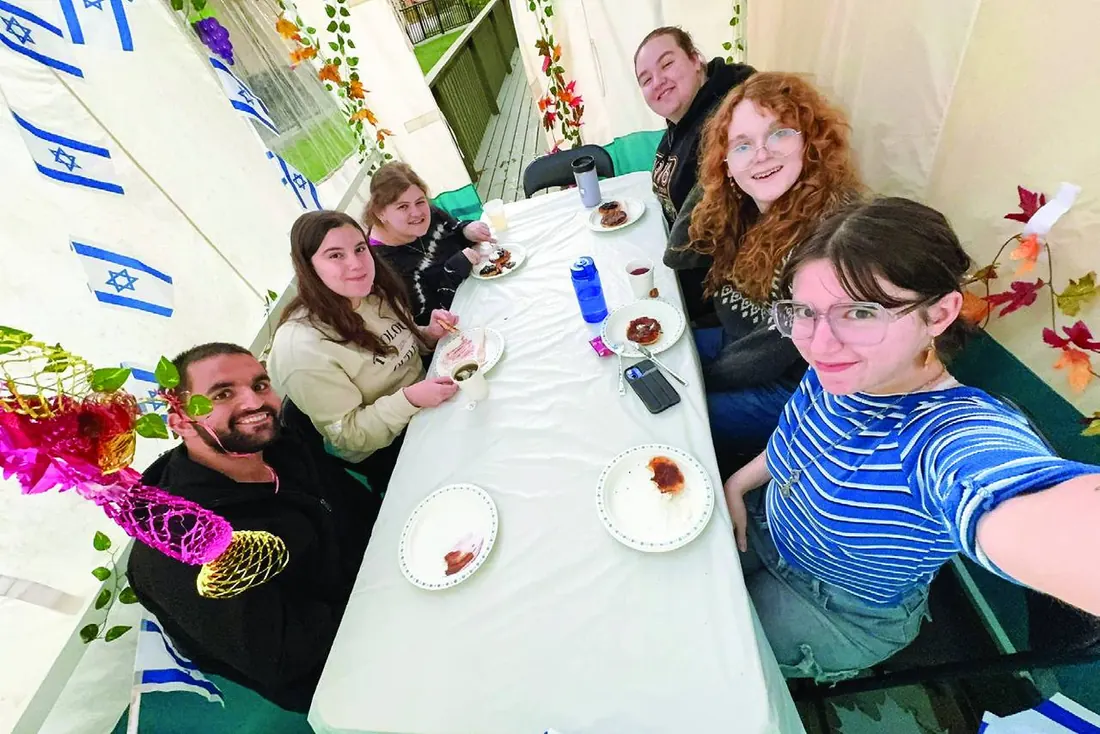 Students celebrating Sukkot in their own sukkah at Hillel Queen's