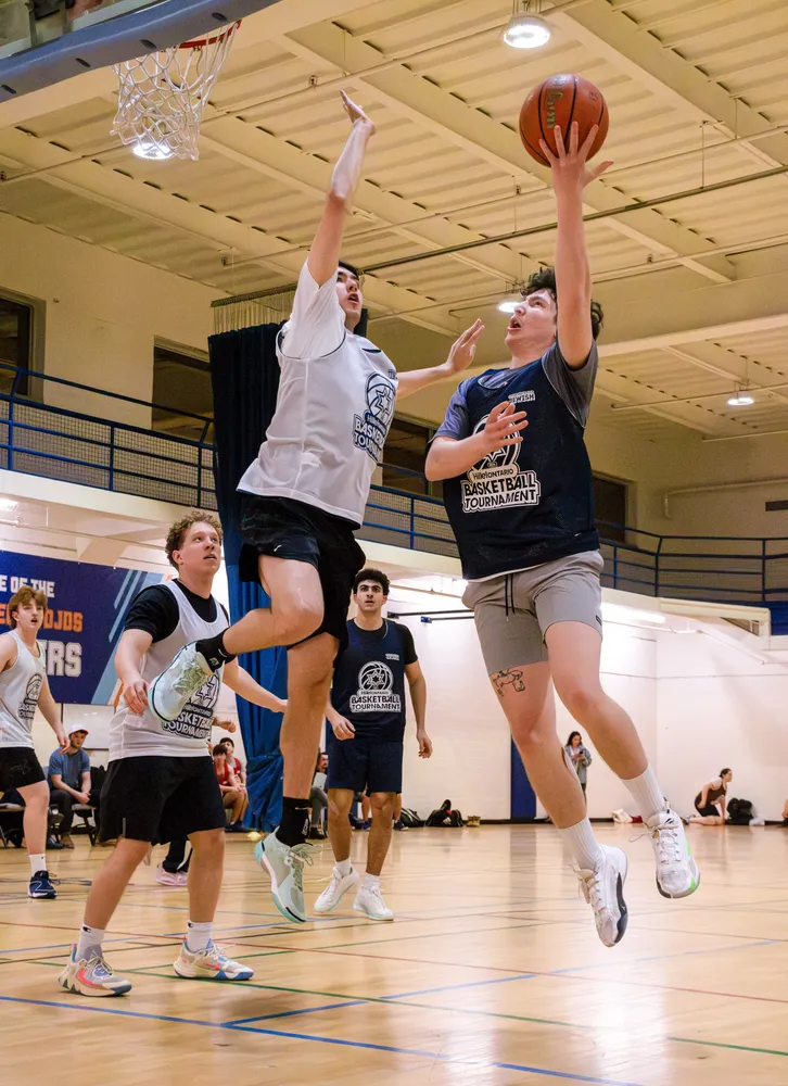 A player rises for a layup over a defender