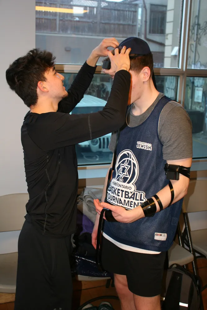 Two students in tournament jerseys share a moment between games