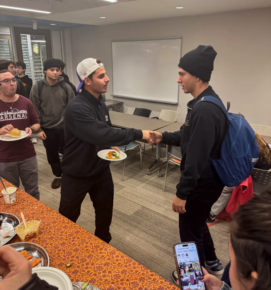 Yoel Levy greets a student over dinner during a campus visit