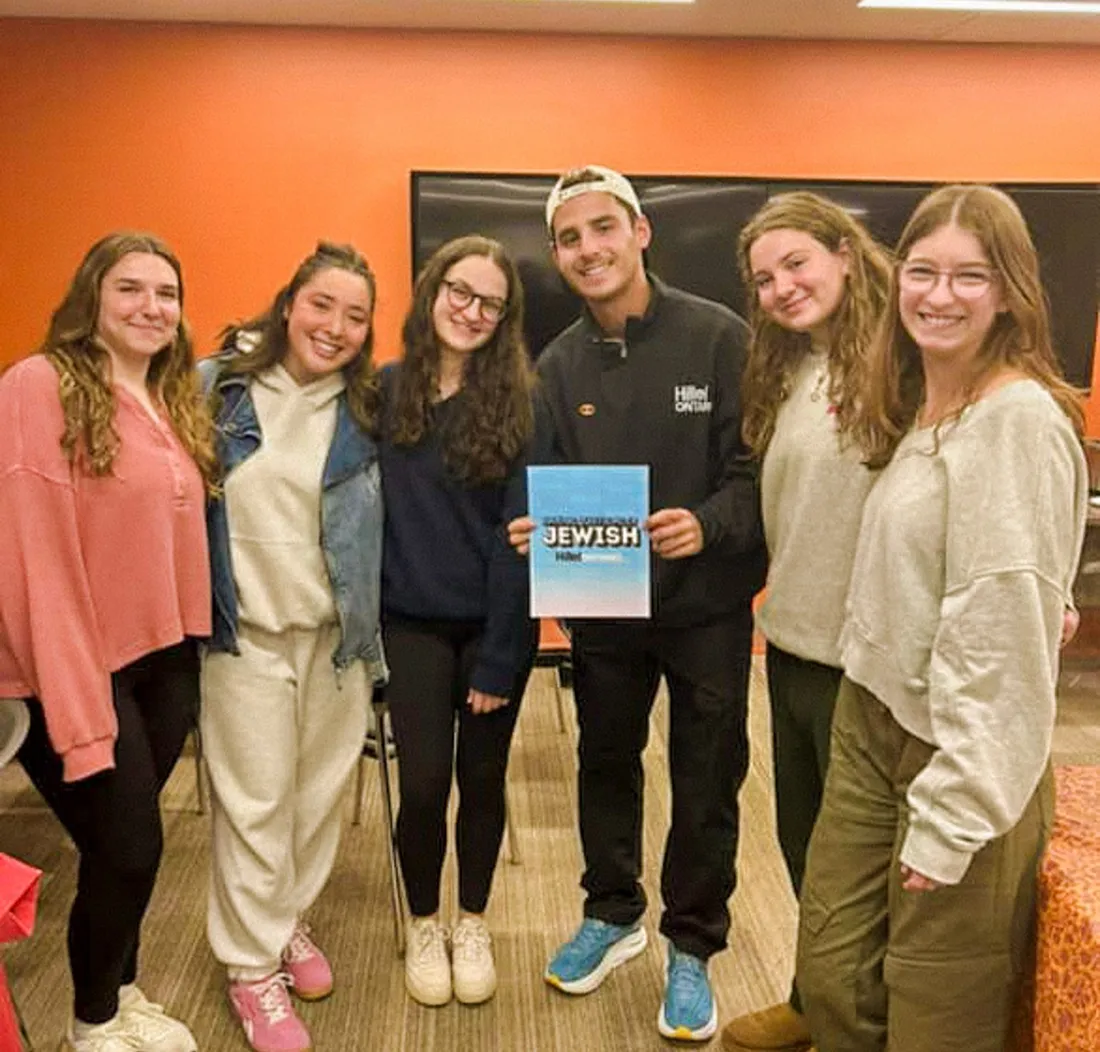 Yoel Levy with students holding an Unapologetically Jewish sign