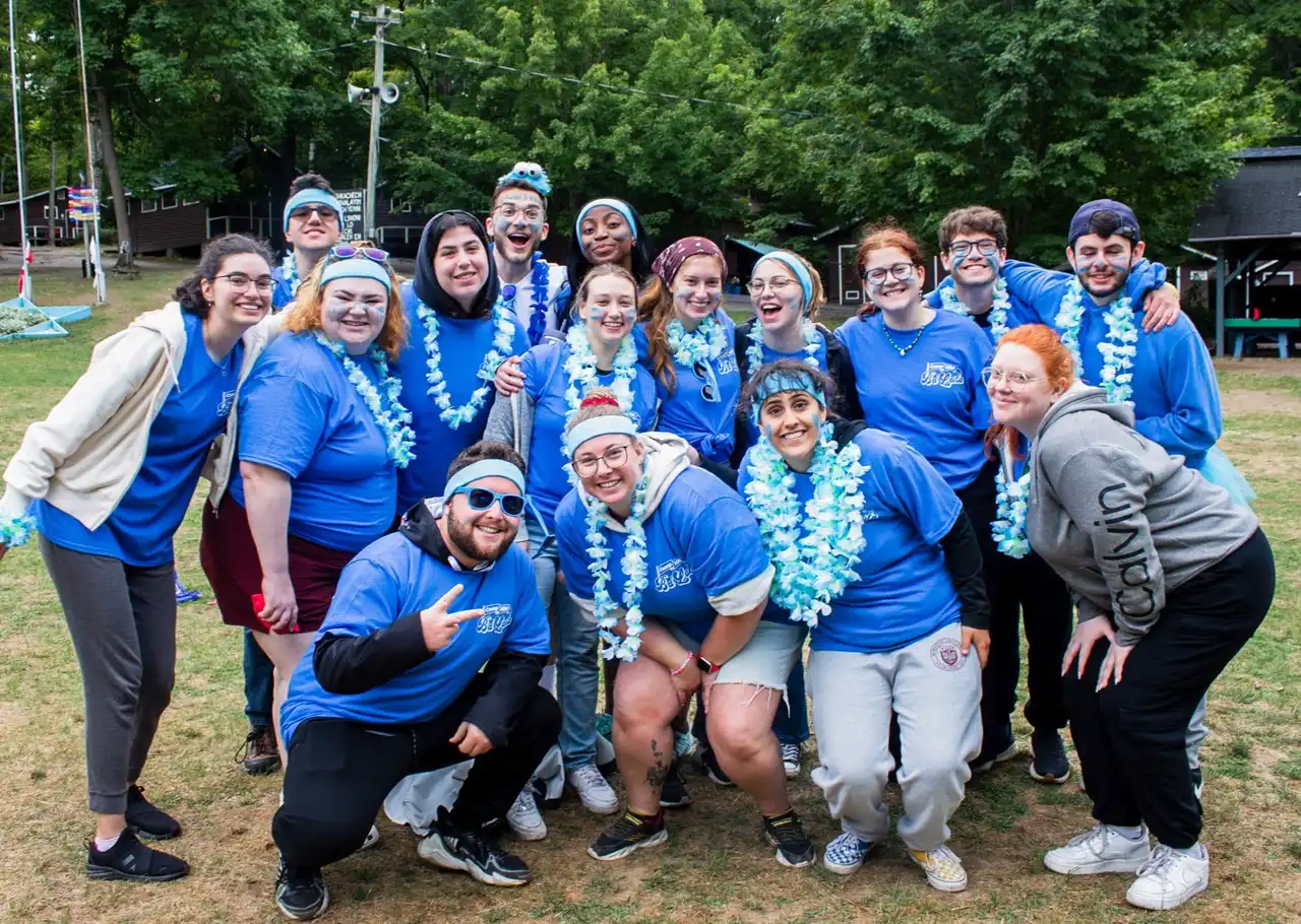 Campers in Camp Hillel Balaila shirts and leis gathered on the field