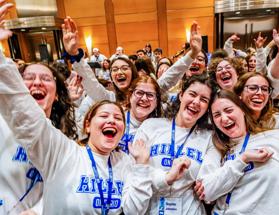 Students in Hillel sweaters laughing together mid-celebration