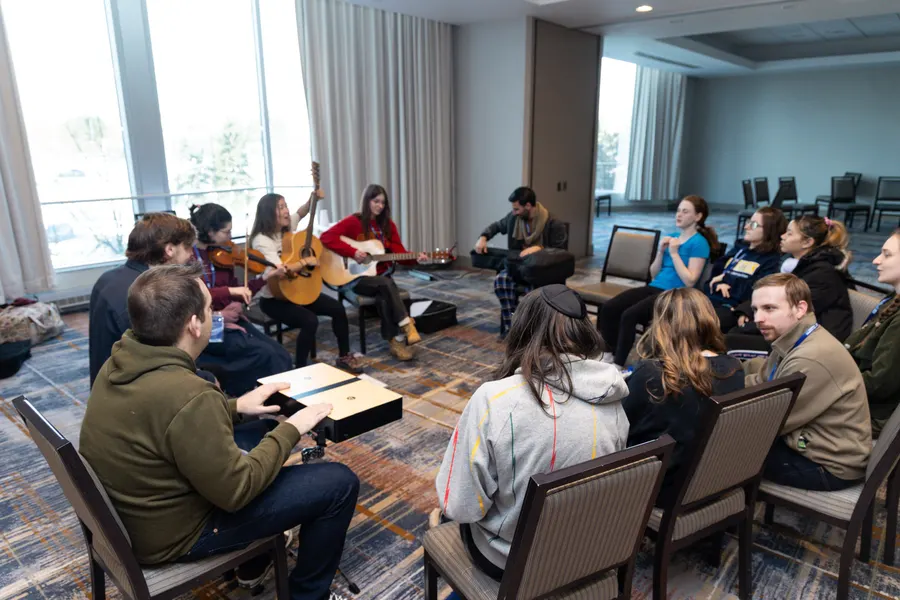 Students gather around guitars for a music session