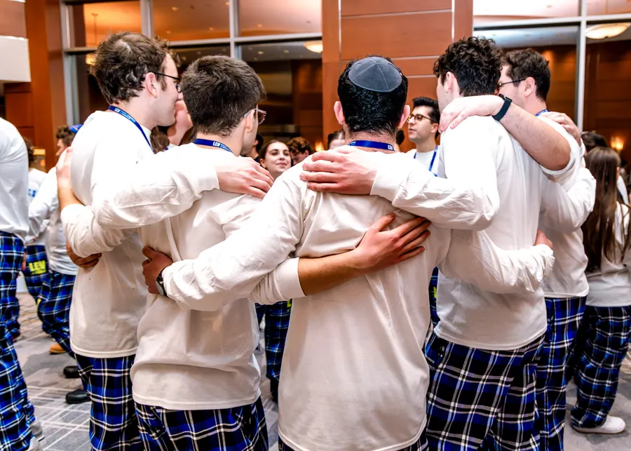 Friends link arms around shoulders in a huddle