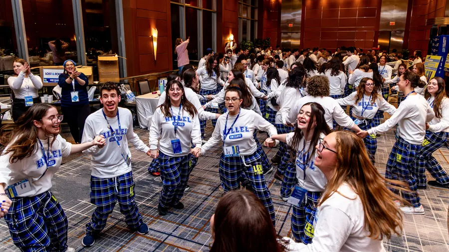 Students dance together in ELEVATE plaid