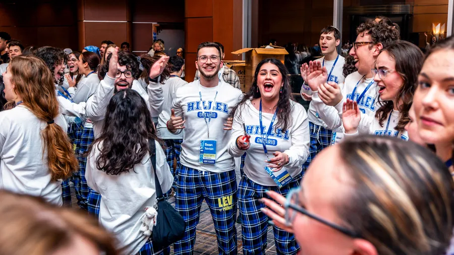Students cheer in a circle in Hillel sweaters