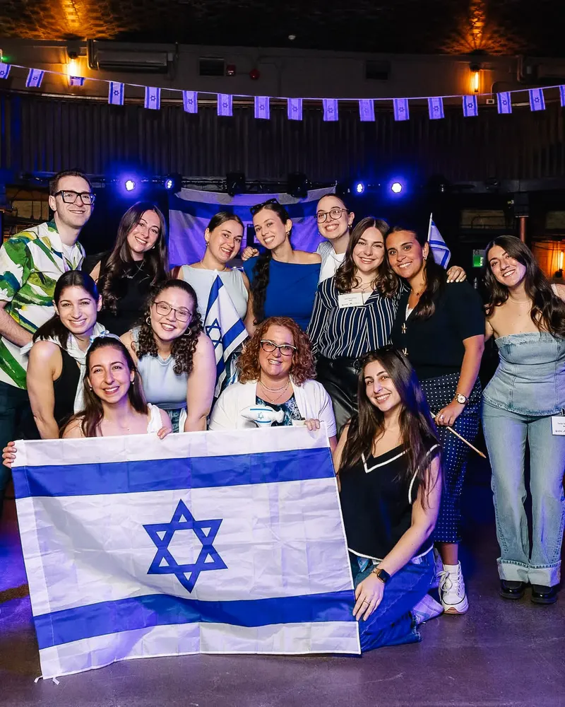 Young professionals gathered with an Israeli flag
