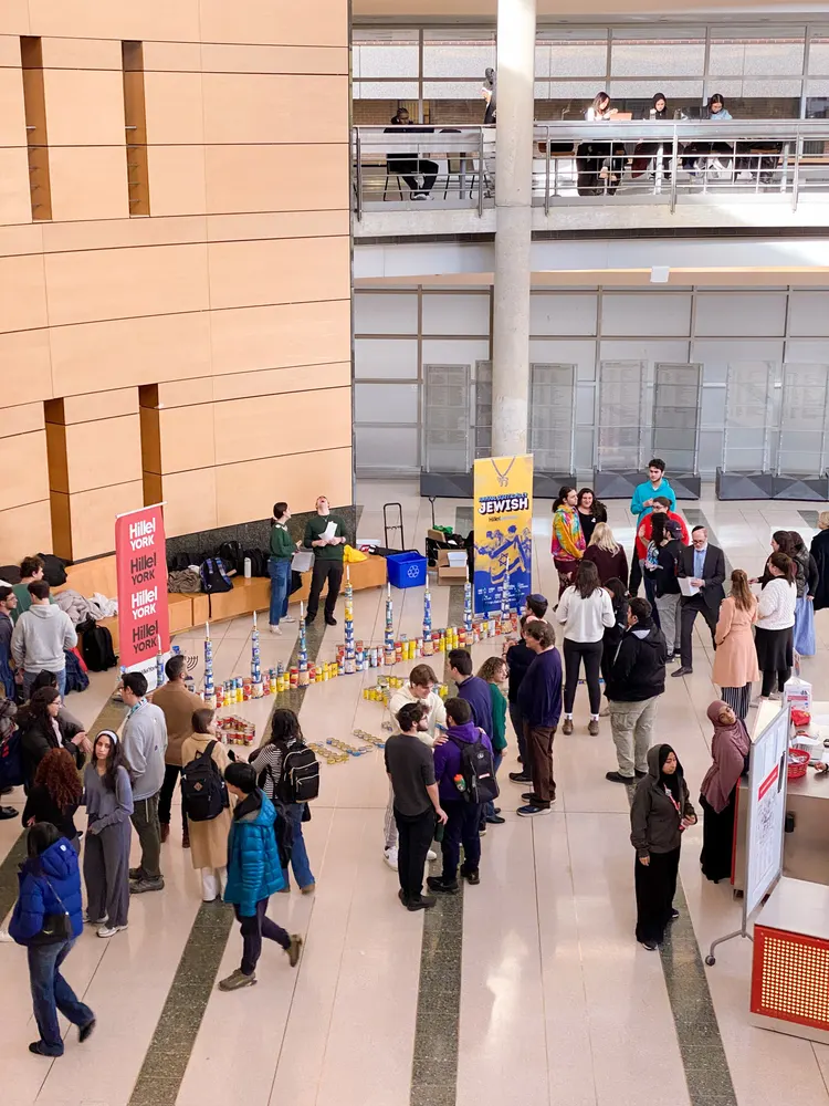 Students tabling in a busy campus atrium during a Hillel York food-drive