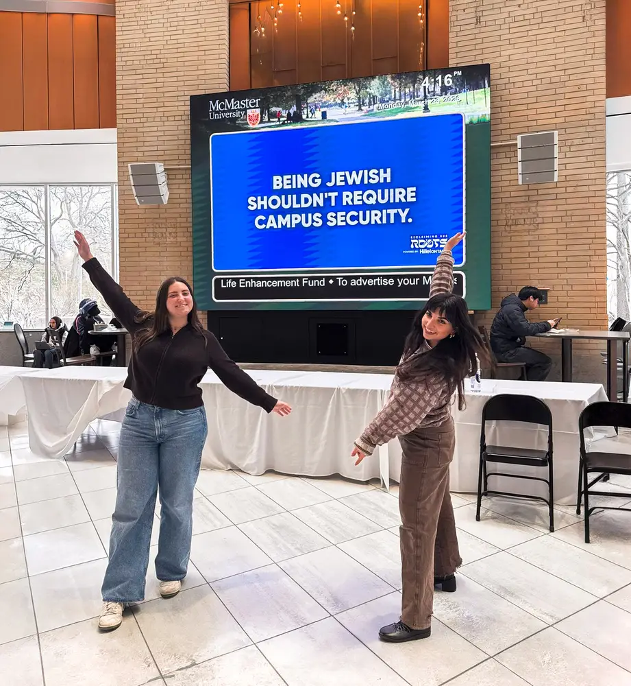 A student gestures at a screen reading Being Jewish Shouldn’t Require Campus Security