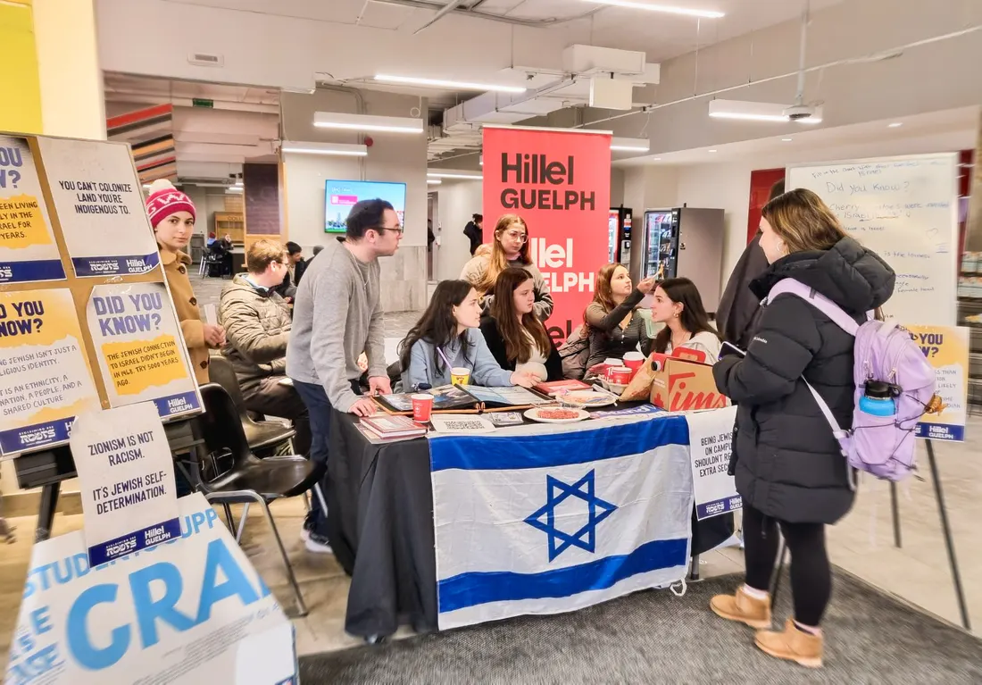 Hillel Guelph students tabling with an Israeli flag for Reclaiming Our Roots