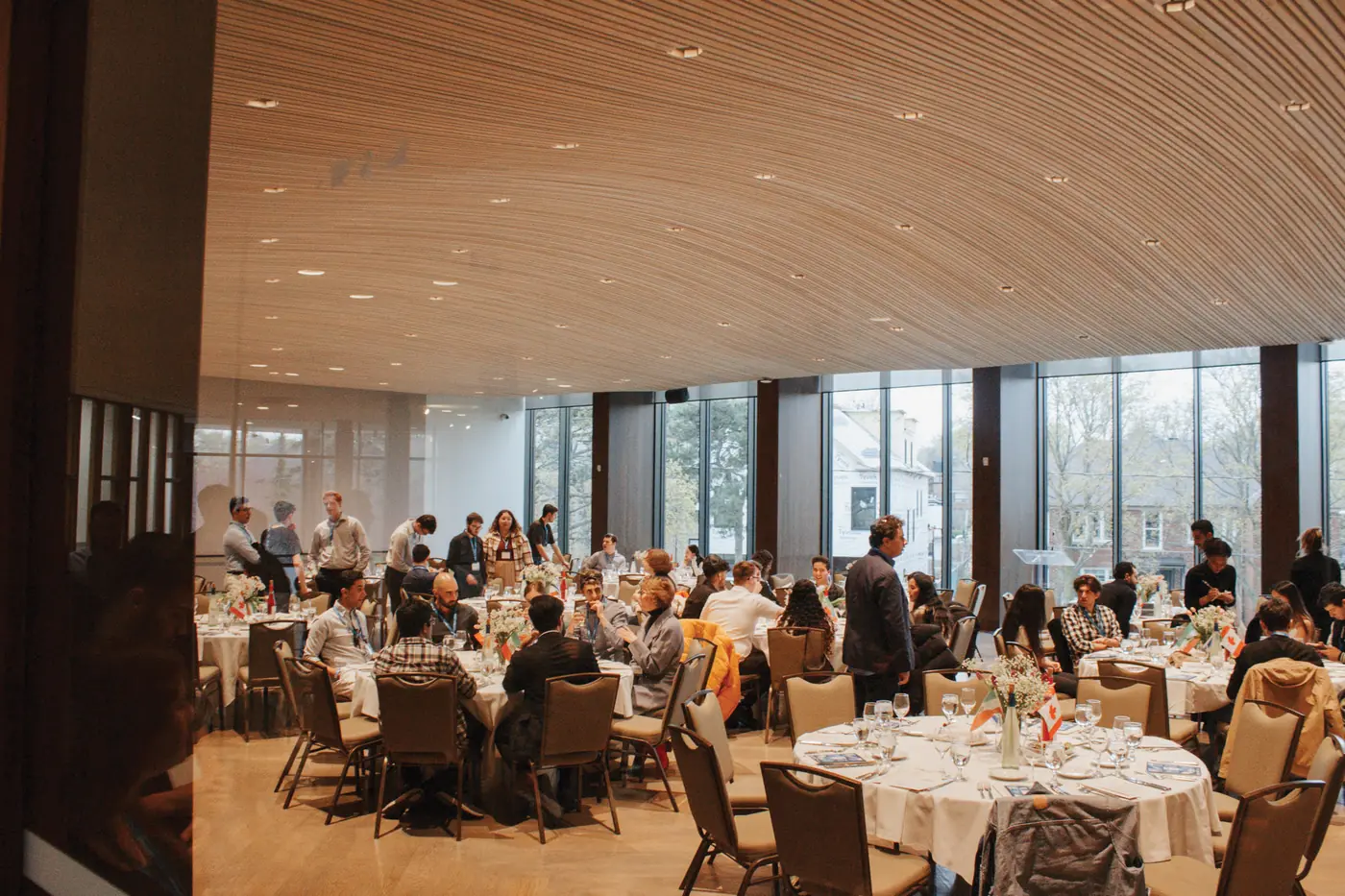A full banquet room of students at round Shabbat tables at Beth Tzedec