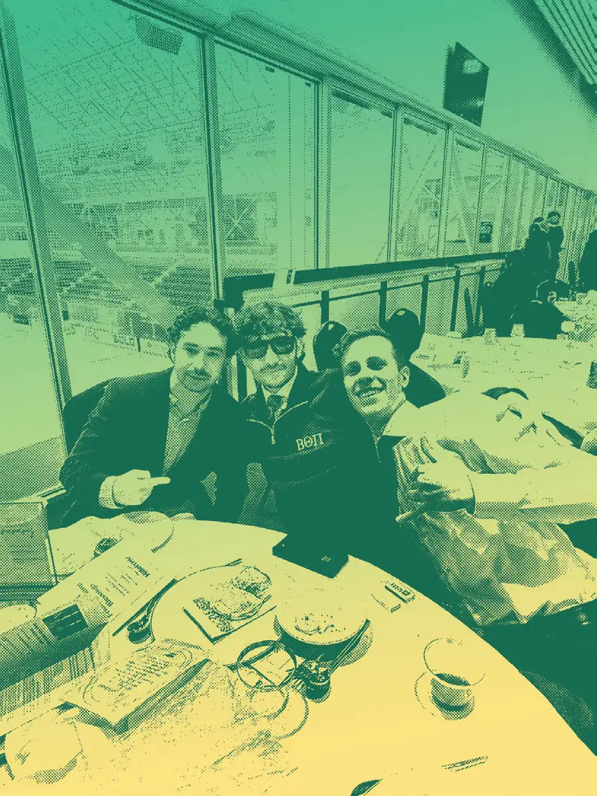 Three students sharing a table at the Hillel TMU multifaith Shabbat dinner, in green-gold duotone