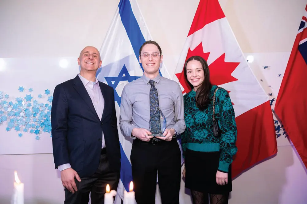Gabe Kaplan receiving the Modern Maccabee Award in front of Israeli and Canadian flags