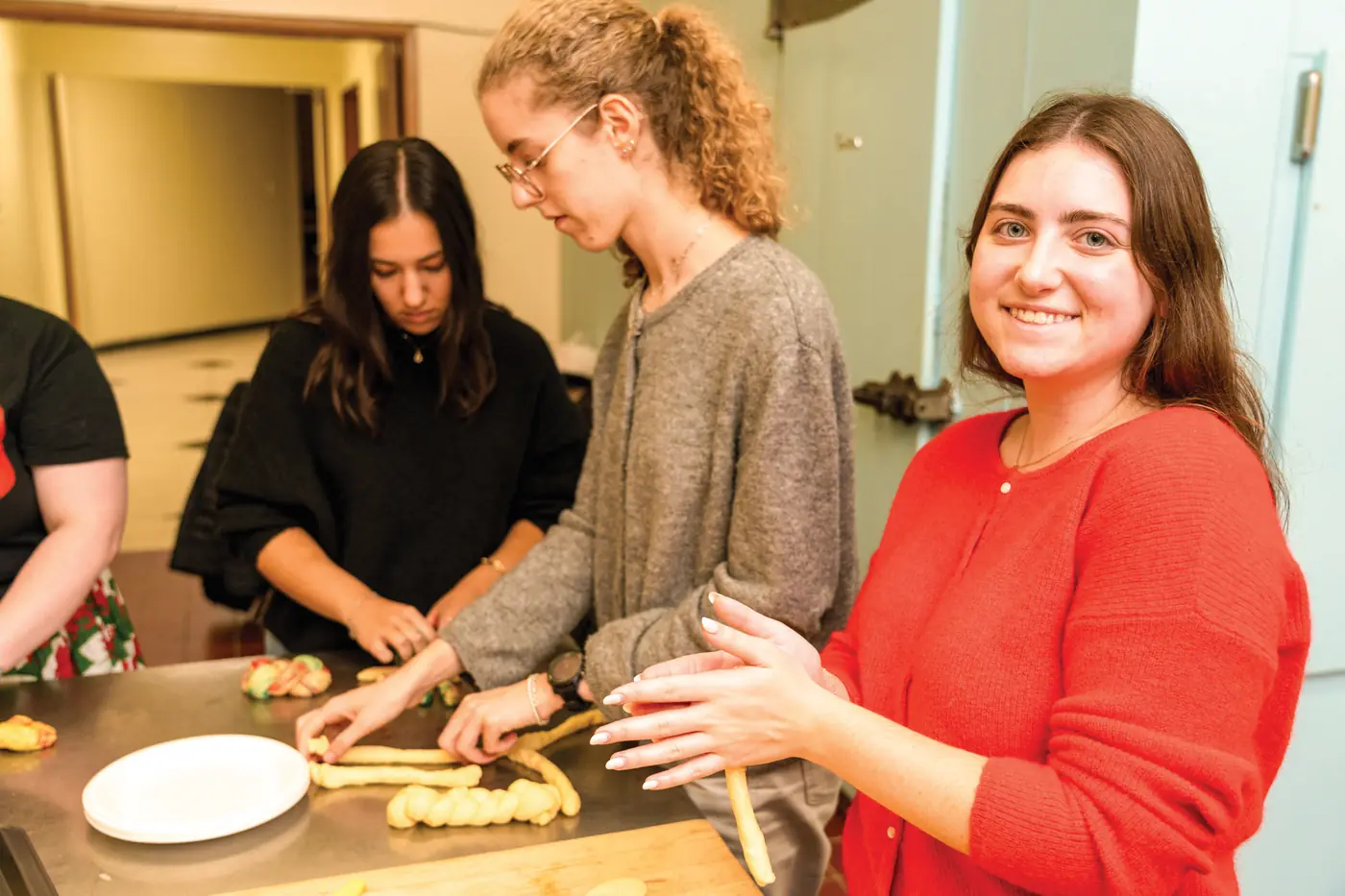 Students braiding challah together in a Hillel kitchen